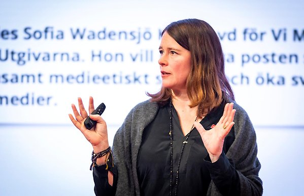 Sofia Wadensjö Karén gives a lecture in front of a projection on the wall