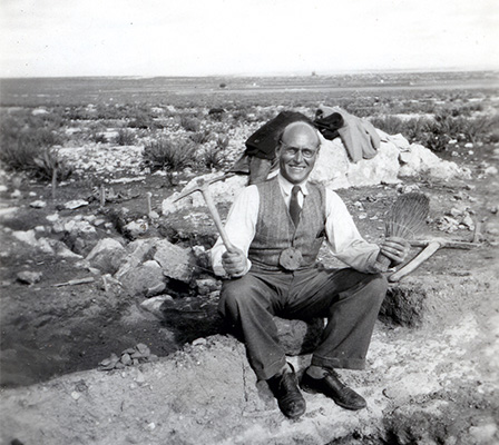 A man sitting next to an excavation.