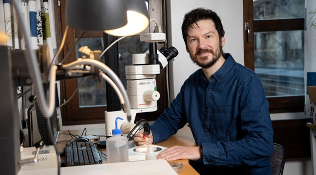Ben Slater, paleontolog vid institutionen för geovetenskaper vid Uppsala universitet, studerar mikroskopiskt små fragment av organismer som levde alldeles före den kambriska explosionen. 