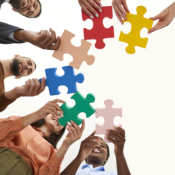 A group of people holding large puzzle pieces