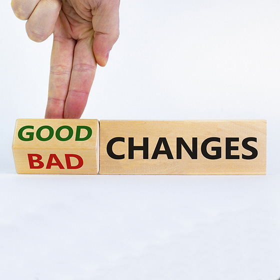Two fingers turning a wooden piece with the words "good" and "bad".