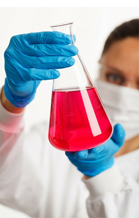 Forskare håller upp behållare med rödvätska