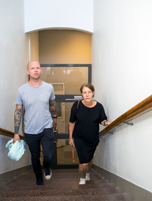 Johannes Einemo och Charlotta Holmström går upp för en trapp i ett trapphus