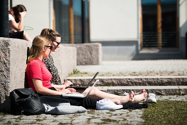 Två studenter sitter med laptops vid EBC