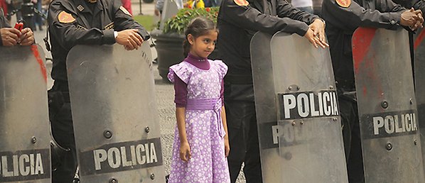 Flicka bland kravallpoliser