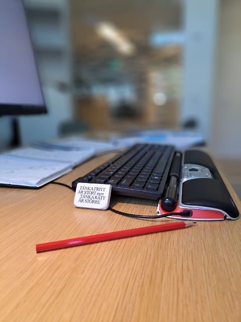 Penna och sudd och ett tangentbord på ett skrivbord