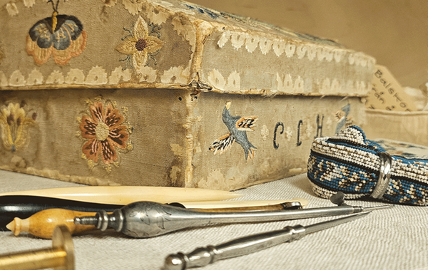 Detaljbild av antikt skrin med verktyg liggande framför.