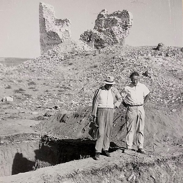two men standing next to each other looking down