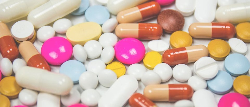 Många antibiotikatabletter av flera olika sorter ligger utspridda.