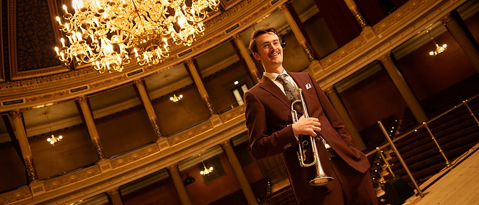 Erik Tengholm in the University Hall with a trumpet.