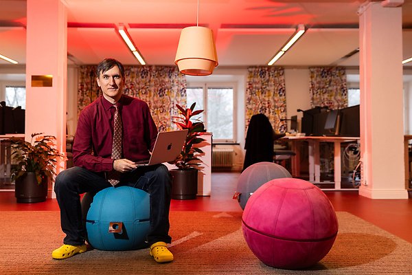 Matteo Magnani sits on a bean bag chair shaped like a ball. He has his laptop in his lap.