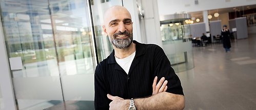 porträtt av Hassan Sharif vid glasvägg i Blåsenhus
